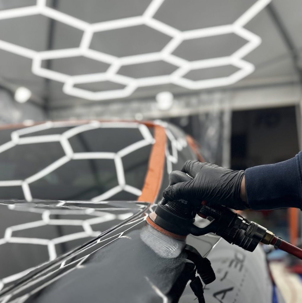 Polissage d’une carrosserie sous éclairage hexagonal à Trappes, formation detailing pour la Belgique